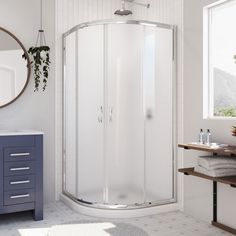 a white bathroom with a corner shower stall and blue drawers on the side of the wall