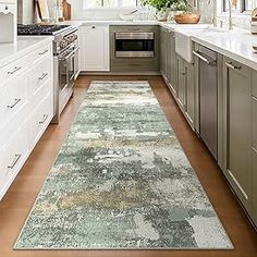 a kitchen with an area rug on the floor next to the stove and cabinets in it