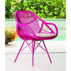 a pink chair sitting on top of a white tile floor next to a swimming pool