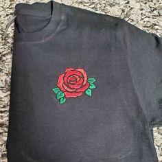 Pretty embroidered t-shirt with a red rose design. A name can be added above or below the rose Available in any size, made to order. Enter customization when you place your order. - The color of T-shirt you would like - The name you would like put on the shirt - Any other specifics you would like to add. 100% cotton shirt Embroidered  Unisex fit Red Rose Design, Rose Embroidery Designs, Embroidery T Shirt, Rose Shirts, Rose T Shirt, Rose Embroidery, Hand Embroidery Design Patterns, Custom Shirt, Embroidered Tshirt