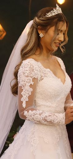 a woman in a wedding dress is holding her hand out to the man who is wearing a tiara