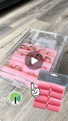 a clear box filled with lots of pink jewelry