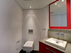 a bathroom with a toilet, sink and mirror