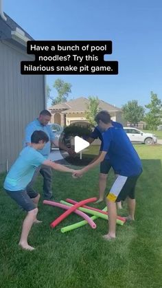 three people playing with inflatable pool toys on the grass near a house and car