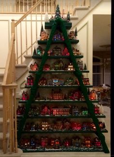 a christmas tree made out of legos in front of a staircase with ornaments on it