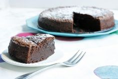 two pieces of chocolate cake on plates with forks