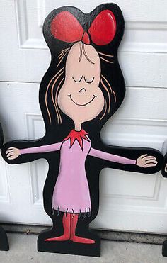 a wooden cutout of a girl holding two hands