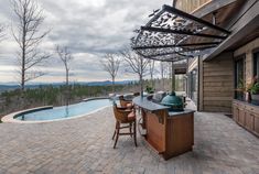 an outdoor kitchen next to a swimming pool