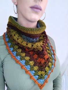 a woman wearing a multicolored crocheted scarf