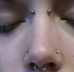 a close up of a person with piercings on their nose and nose rings in front of them