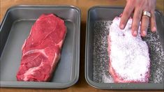 two trays filled with raw meat sitting on top of a table