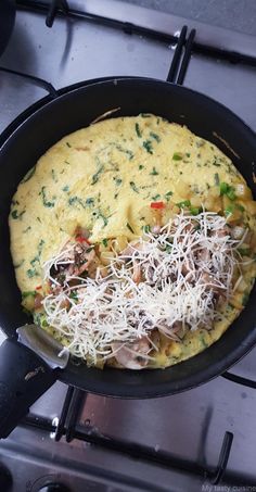 an omelet with mushrooms, cheese and parmesan on top is being cooked in a skillet