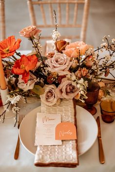 the table is set with flowers and place settings