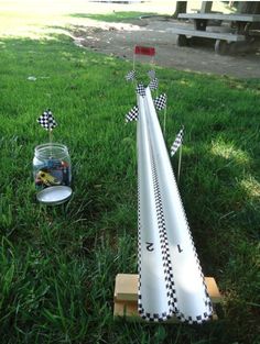 an upside down race track in the grass next to a fish bowl and toothbrush holder