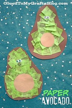 two paper avocados made to look like they are sitting on the ground with stars around them