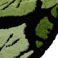 an area rug with green and black designs on the carpet is shown in close up