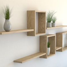 three wooden shelves with plants and vases on them