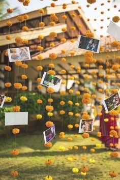 an outdoor area with flowers and pictures hanging from it's ceiling, in the middle of