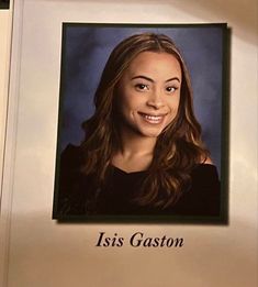 an image of a woman with long hair smiling at the camera in front of a plaque