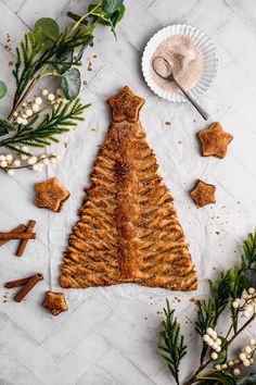 a christmas tree made out of crackers on top of a white table with greenery