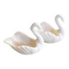 two white swan shaped bowls sitting next to each other