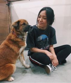 a woman sitting on the floor with her dog