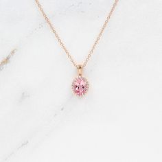 The Charlotte Necklace in Rose Gold against a white background Fine Jewelry Pink Oval Necklace, Pink Oval Fine Jewelry Necklaces, Pink Oval Fine Jewelry Necklace, Elegant Pink Sapphire Jewelry With Halo Design, Elegant Pink Sapphire Halo Jewelry, Pink Oval Cubic Zirconia Necklaces, Pink Oval Cubic Zirconia Necklace, Pink Sapphire Jewelry With Halo Design For Gifts, Elegant Pink Oval Pendant Necklace