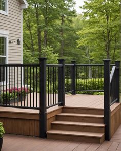 a wooden deck with black railing and steps