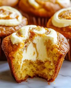 several cupcakes with white frosting on them sitting on a marble counter top