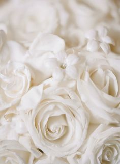 a bouquet of white roses sitting on top of a table