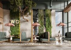 the interior of a modern restaurant with green plants on the walls and tables in front of them