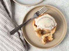 a plate with a pastry on it next to a cup of coffee and a fork