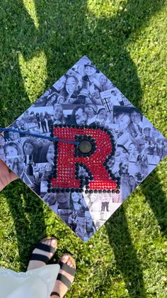 a person is holding up a graduation cap with pictures on it and the letter r