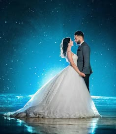 a bride and groom standing in the water at night with bright stars above their heads