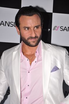 a man wearing a white suit and pink shirt