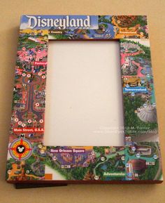 a colorful picture frame is hanging on the wall with an advertisement for disneyland world in it