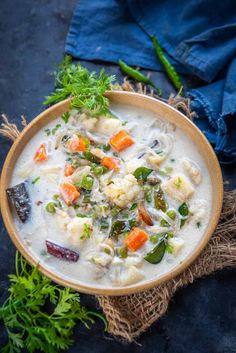 a bowl of soup with carrots, cauliflower and celery