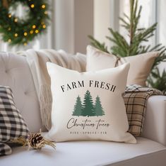 a christmas tree pillow sitting on top of a white couch