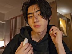 a young man is brushing his hair with an electric razor