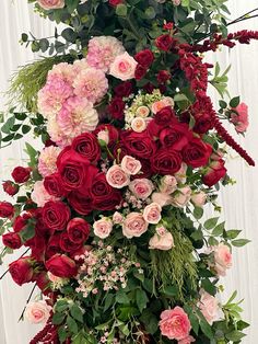 an arrangement of red and pink flowers on top of each other