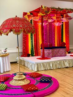 a decorated stage with an umbrella and other decorations on the floor in front of it