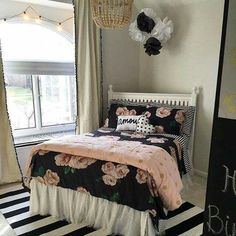 a bedroom with black and white striped flooring and pink flowers on the comforter