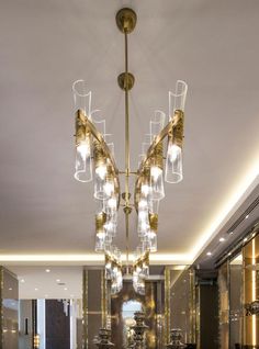 a fancy chandelier hangs in the middle of a dining room with marble tables and chairs