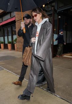 a man and woman walking down the street with an umbrella