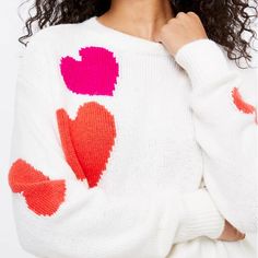 a close up of a person wearing a sweater with hearts painted on the front and back