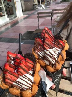 two baskets filled with strawberries and chocolate covered cookies