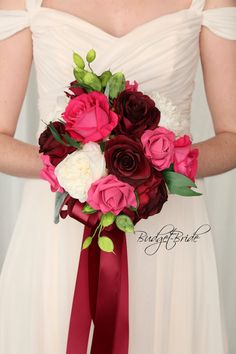 a bridal holding a bouquet of red and white flowers