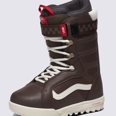 a brown snowboard boot with white laces and red accents on the bottom side