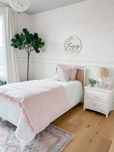 a bedroom with white walls and pink bedding