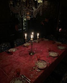 a table with plates and silverware on it in the middle of a dark room